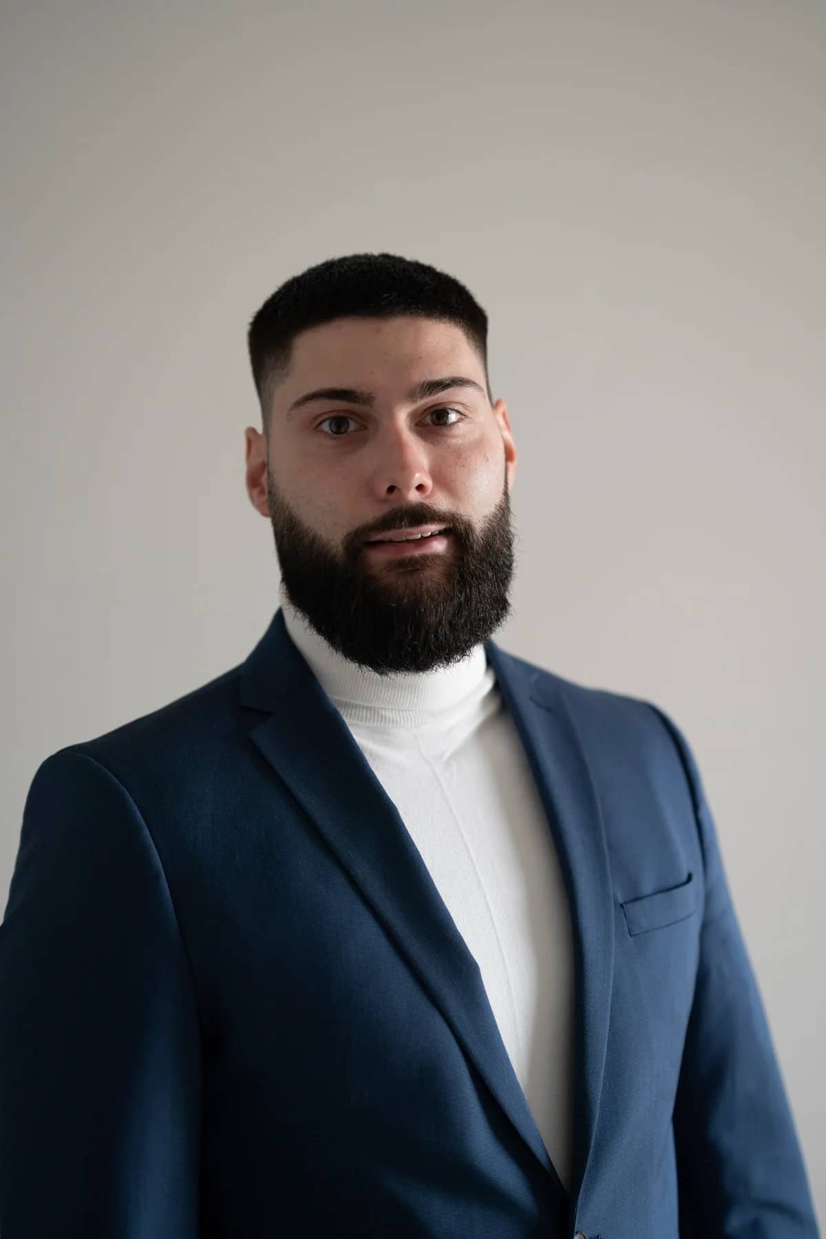 Marc Derlich, Inhaber von DERLO Consulting & Protection, im blauen Sakko vor hellem Hintergrund.